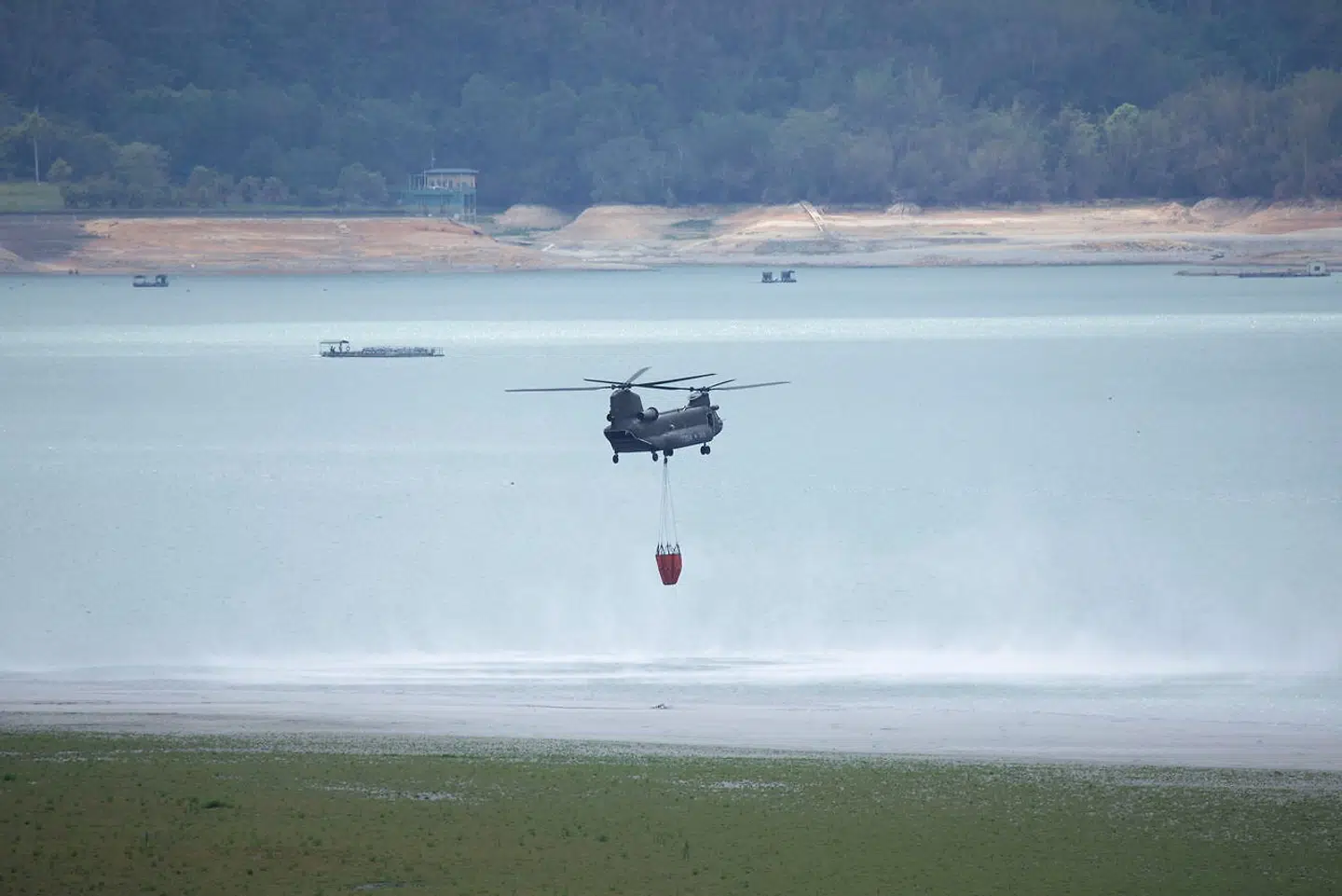 En helikopter henter vand for at slukker en skovbrand i nærheden af Sun Moon-søen.