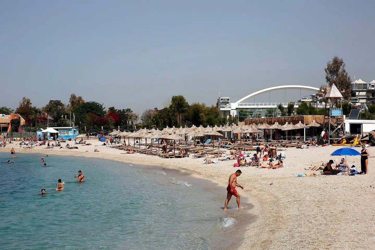 Grækenland og de græske strande som denne strand nær Athen genåbnede i maj med coronabegrænsninger, men nu stiger smittetallet på en række græske øer.