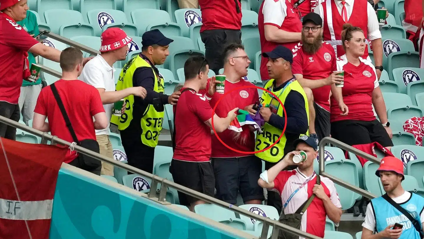 En steward på stadion i Baku ser ud til at konfiskere et regnbueflag fra danske fans.