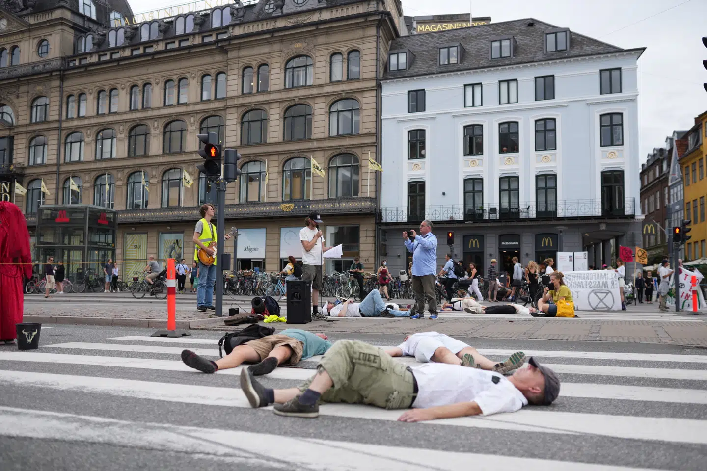 Flere mennesker ligger ud for metrostationen ved Kongens Nytorv.