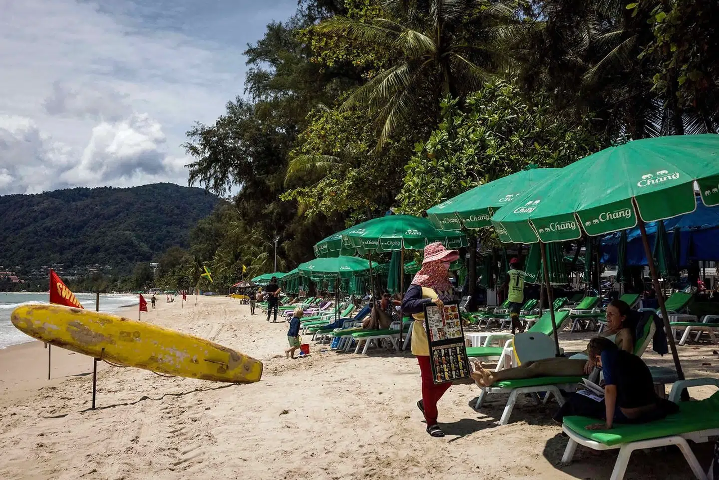 En kvinde forsøger at lokke en turist til at købe en forfriskning på en strand på Phuket 14. august.