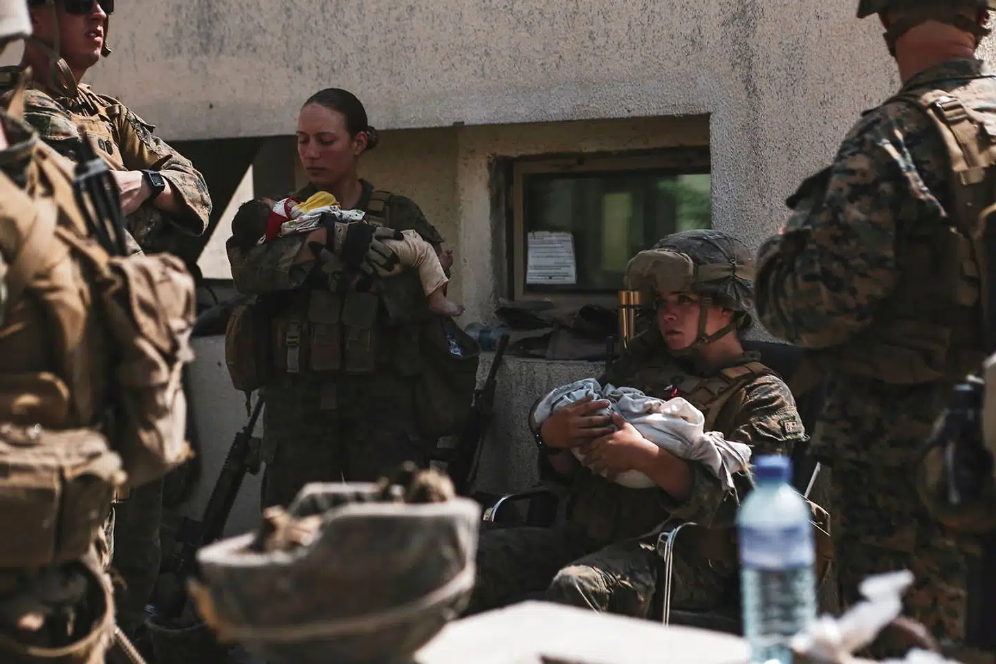 Nicole Gee ses her stående med en baby i armene.