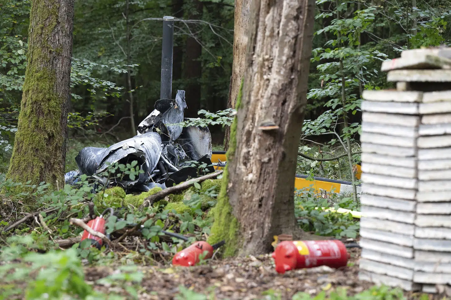 Rester fra en helikopter af typen Robinson R44 ligger i skovbunden uden for byen Buchen i Tyskland. Politiet formoder, at en pilot og to passagerer er omkommet. Sebastian Gollnow/Ritzau Scanpix
