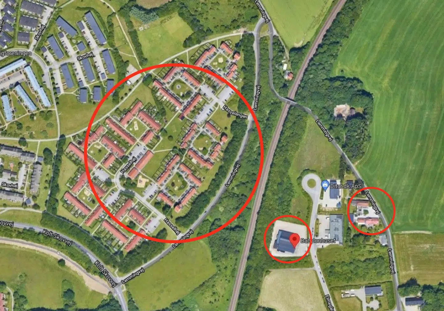 OVERBLIK: Den store cirkel indkapsler beboelsesområdet ved Hasselhøj og Hasselengen. På den anden side af træerne og jernbanen ses Babylon Huset, som er markeret med en mindre rød cirkel. På vejen, hvor Babylon Huset ligger, er det mest virksomheder, som holder til, men på den anden side af Lemmingvej er der ligeledes privatbeboelse. Foto: Google Street View