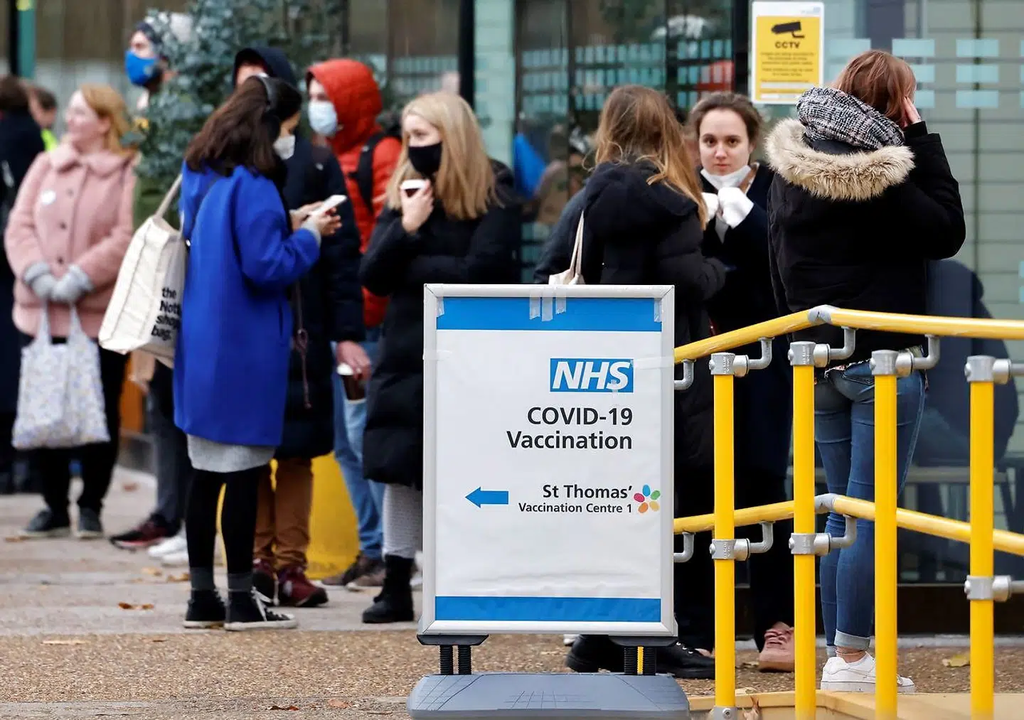 Members of the public queue to receive a dose of a Covid-19 vaccine at a coronavirus vaccination centre outside Guy's and St Thomas' Hospital in central London on December 13, 2021. - UK Prime Minister Boris Johnson on Monday said at least one person infected with Omicron had died, as the country began an ambitious booster programme against the variant. (Photo by Tolga Akmen / AFP)