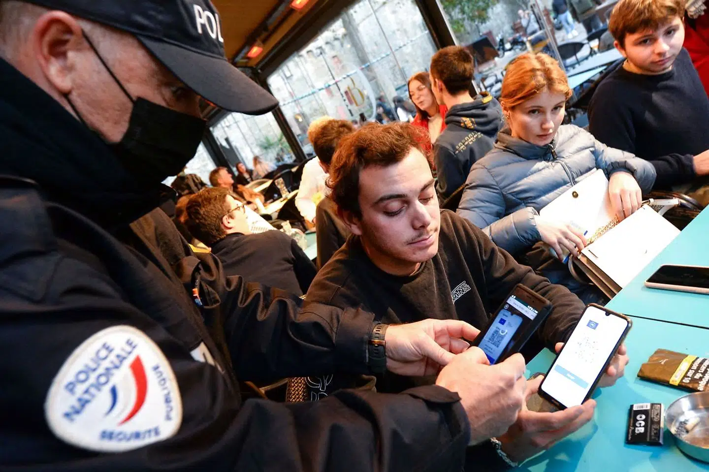 En politimand tjekker coronapas på en bar i den vestfranske by Saint-Malo.
