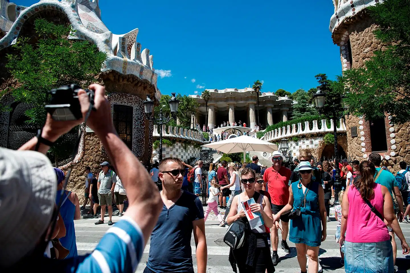 Turister i Park Guell i Barcelona. Ifølge spanske aktivister har turismen taget overhånd i byer som Barcelona og Palma de Mallorca.