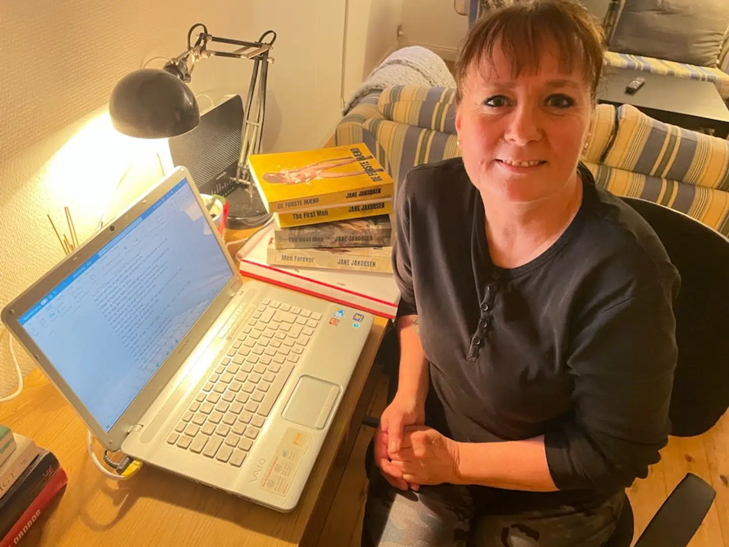 Her sidder Jane Jakobsen ved sin computer i sit hus i den lille by Klokkerholm i Nordjylland. Foto: Privat