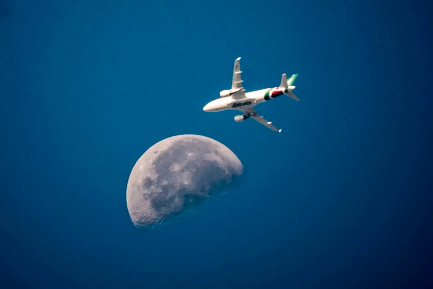 Her ses et italiensk Alitalia-fly med månen i baggrunden over Rom 3. august 2018.