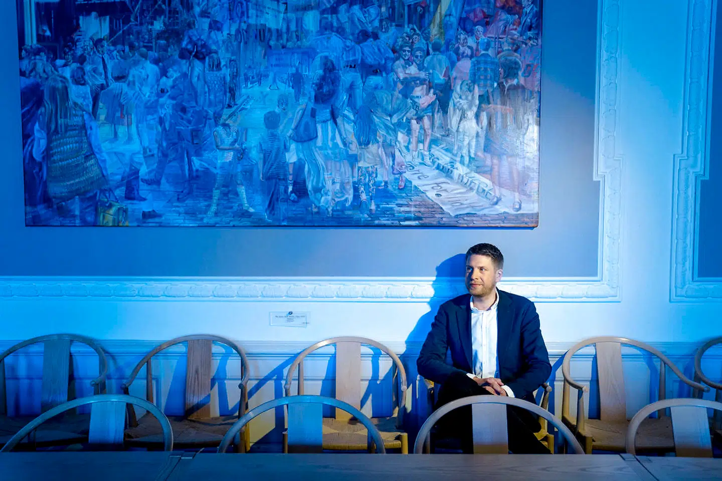 Kulturordfører for Socialdemokratiet, Kasper Sand Kjær fotograferet under Jacob Brostrups maleri af Socialdemokratiets historie. Her maleriet fra 1990erne, der viser tiårets optimisme.