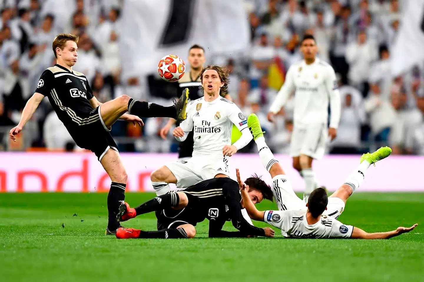 Ajax's Dutch midfielder Frenkie de Jong (L) challenges Real Madrid's Croatian midfielder Luka Modric (C) during the UEFA Champions League round of 16 second leg football match between Real Madrid CF and Ajax at the Santiago Bernabeu stadium in Madrid on March 5, 2019. (Photo by GABRIEL BOUYS / AFP)