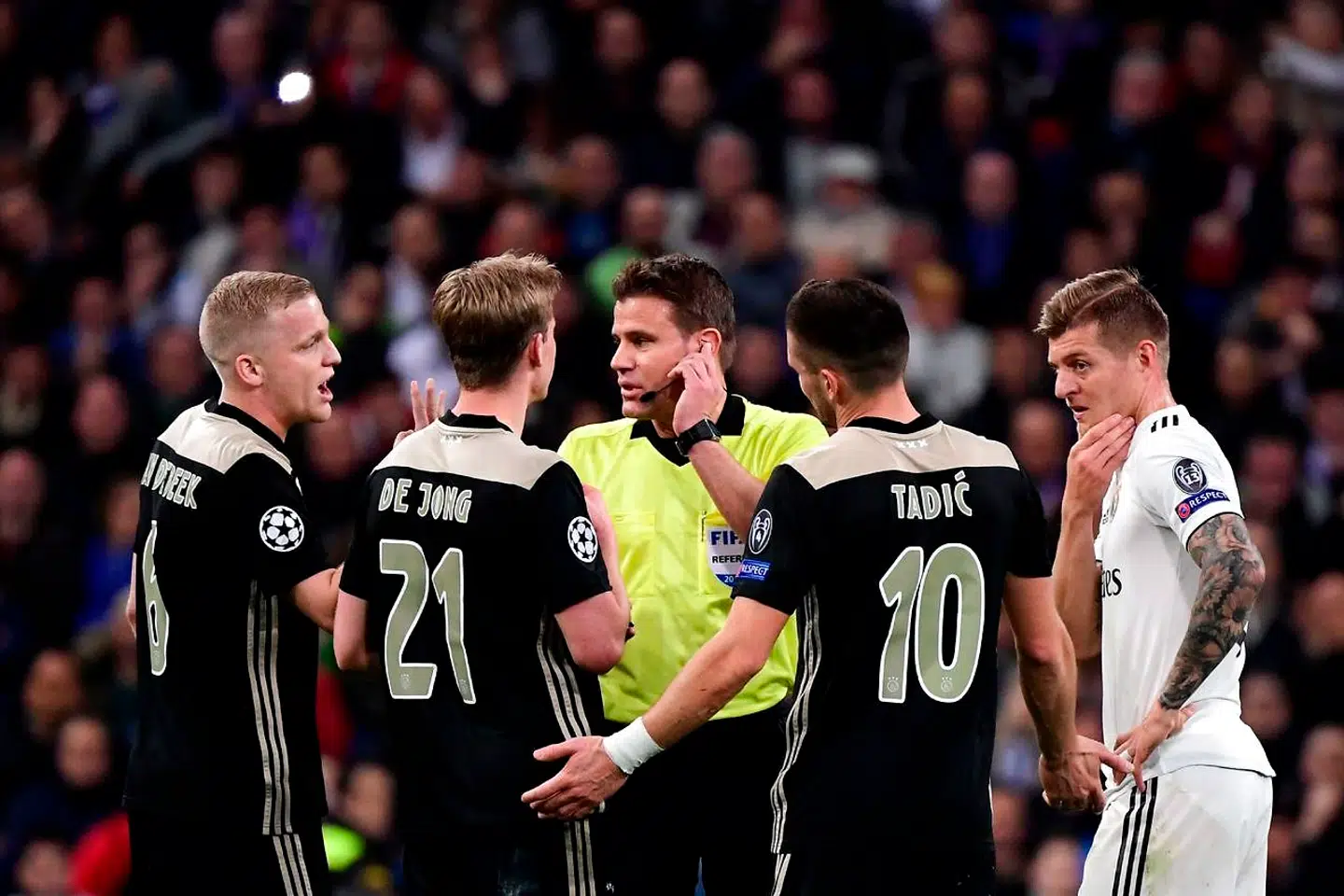 (FromL) Ajax's Dutch midfielder Donny van de Beek, Ajax's Dutch midfielder Frenkie de Jong, Ajax's Serbian forward Dusan Tadic and Real Madrid's German midfielder Toni Kroos argue with German referee Felix Brych during the UEFA Champions League round of 16 second leg football match between Real Madrid CF and Ajax at the Santiago Bernabeu stadium in Madrid on March 5, 2019. (Photo by JAVIER SORIANO / AFP)