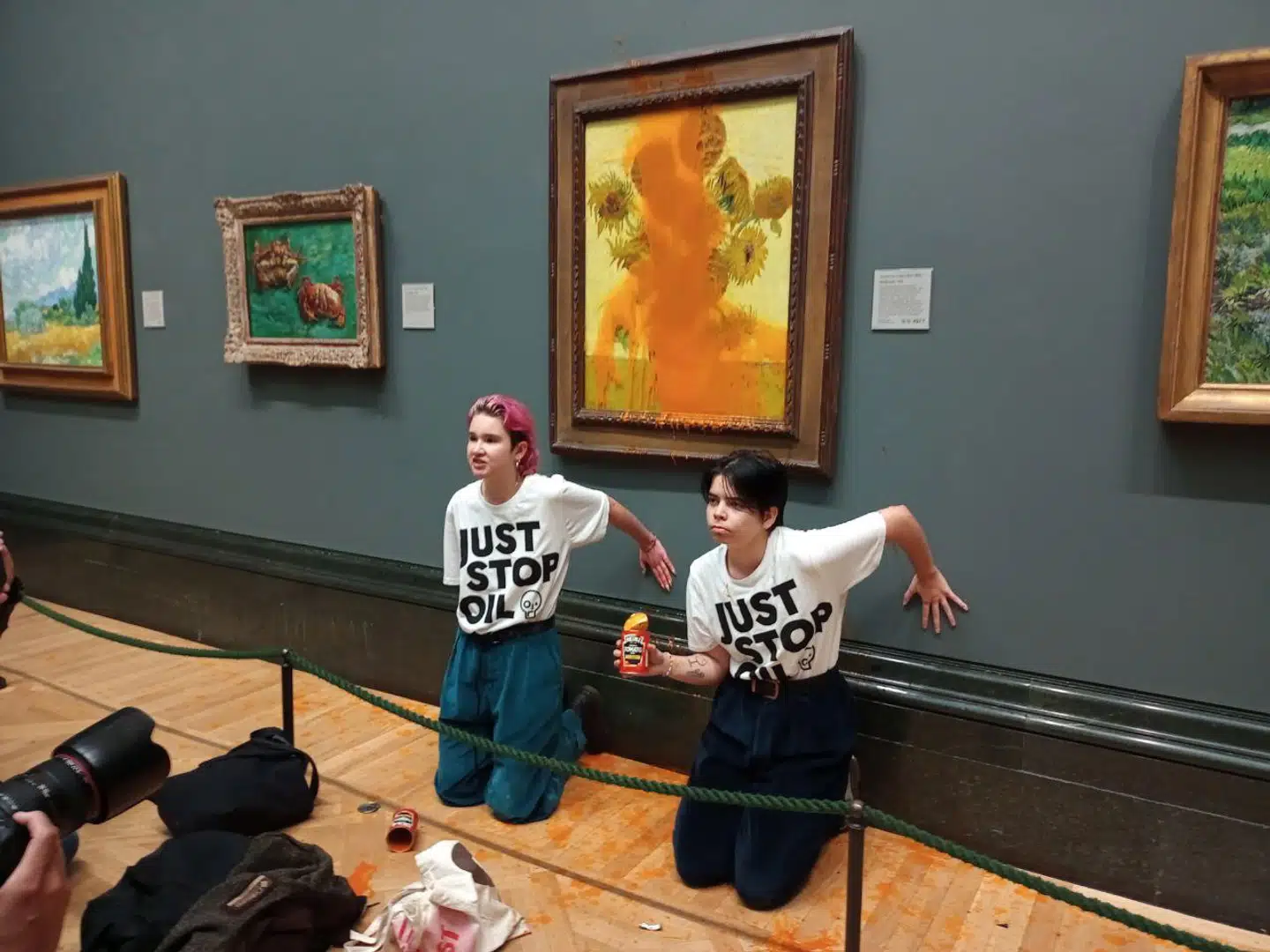 Den 14. oktober hældte to aktivister tomatsuppe på Vincent van Goghs berømte solsikkemaleri, som hænger på National Gallery i London. Efterfølgende limede de deres hænder fast til væggen. Foto: Just Stop Oil, Scanpix.