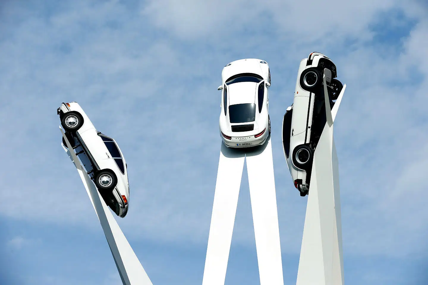 Udenfor Porsches fabrik i Stuttgart-Zuffenhausen står denne skulptur med tre versioner af Porsches legendariske 911-model.