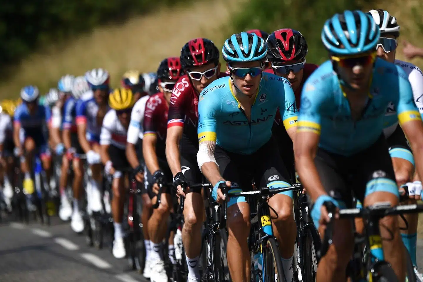 Denmark's Jakob Fuglsang (2ndR) and Great Britain's Geraint Thomas (behind) ride in the pack during the eighth stage of the 106th edition of the Tour de France cycling race between Macon and Saint-Etienne, on July 13, 2019. (Photo by Anne-Christine POUJOULAT / AFP)