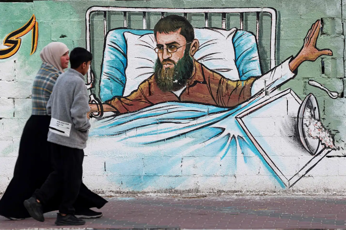 I Gaza er der blevet lavet et vægmaleri, der portrætterer den sultestrejkende Khader Adnan, der tirsdag er død. Mohammed Abed/Ritzau Scanpix