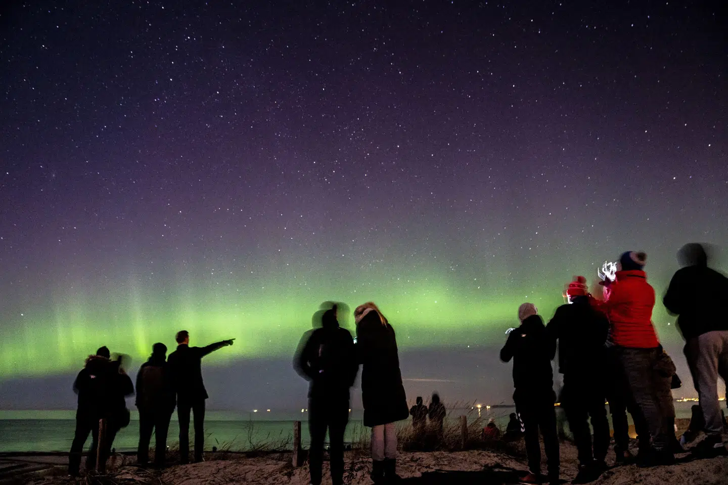 Folk peger mod nordlyset over Danmark - her på Hornbæk Strand i Nordsjælland mandag den 27. februar 2023. Mads Claus Rasmussen/Ritzau Scanpix