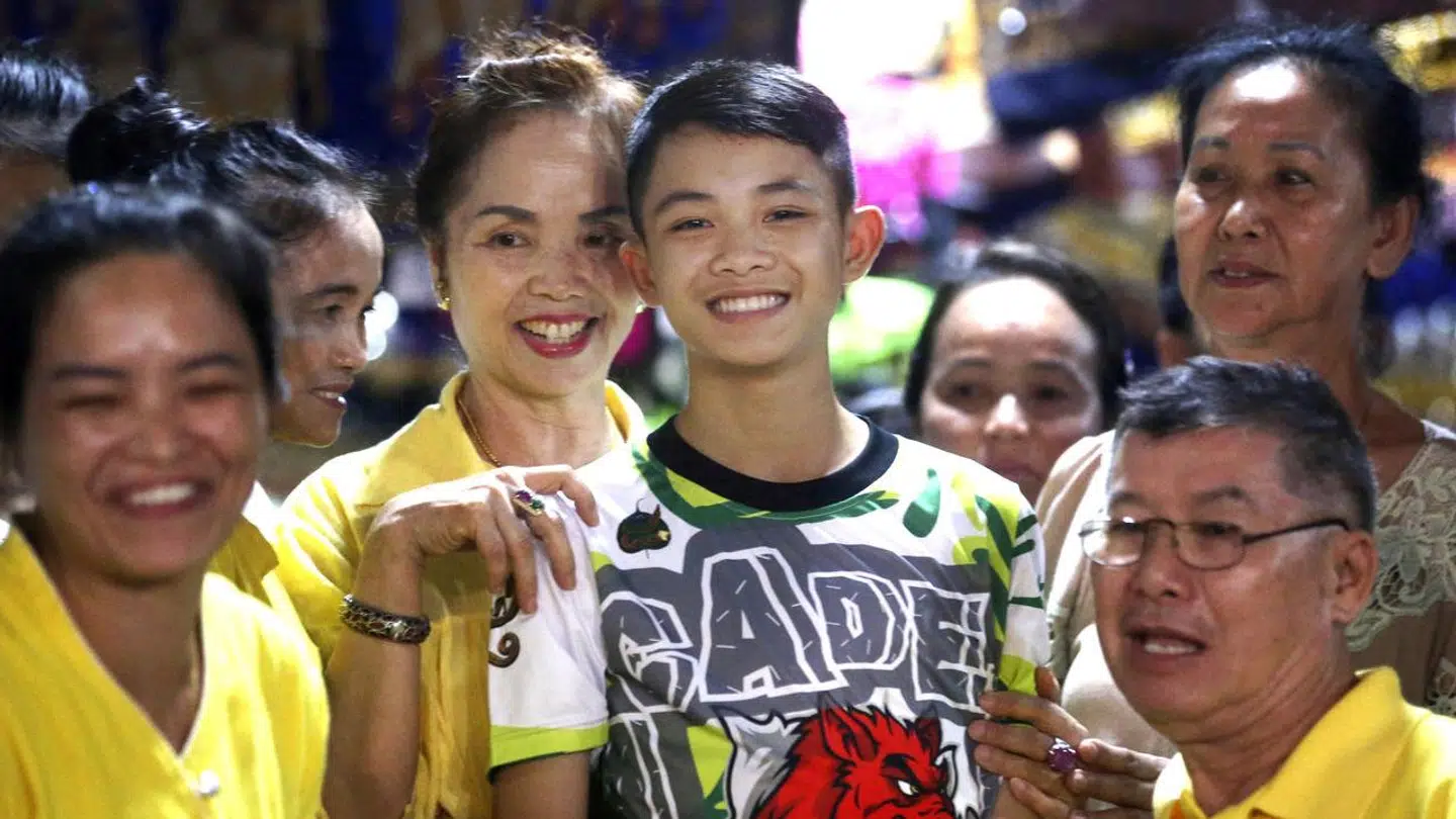 Duangpetch Promthep med sine nærmeste efter han blev reddet ud af grotten. Nu har han på tragisk vis mistet livet 5 år senere. (Foto: Scanpix)