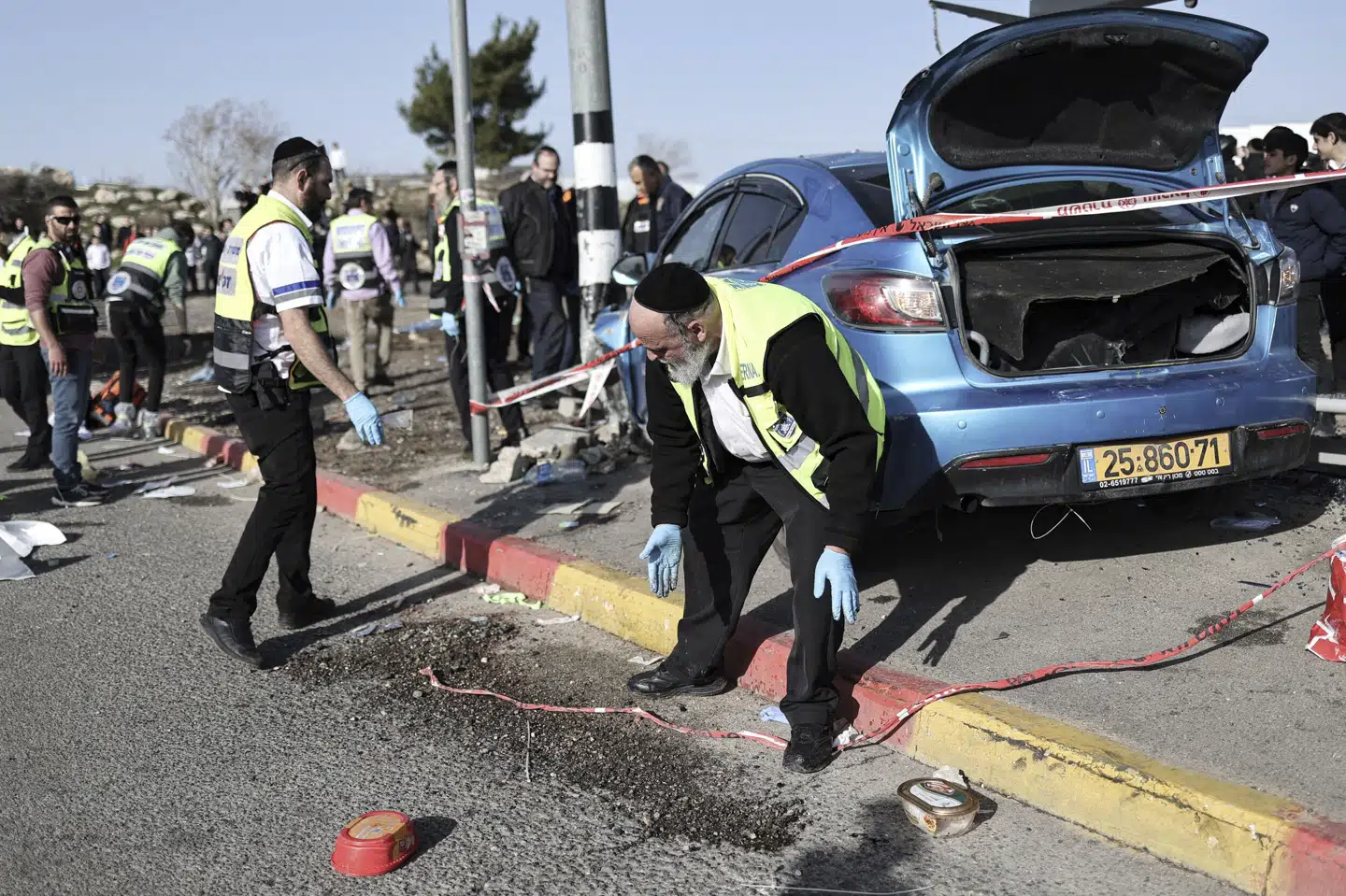 Israelsk redningsmandskab ved det busstoppested i Østjerusalem, hvor en bilist fredag pløjede sin bil ind i en gruppe mennesker. To drenge og en 20-årig studerende er dræbt. Ilia Yefimovich/Ritzau Scanpix