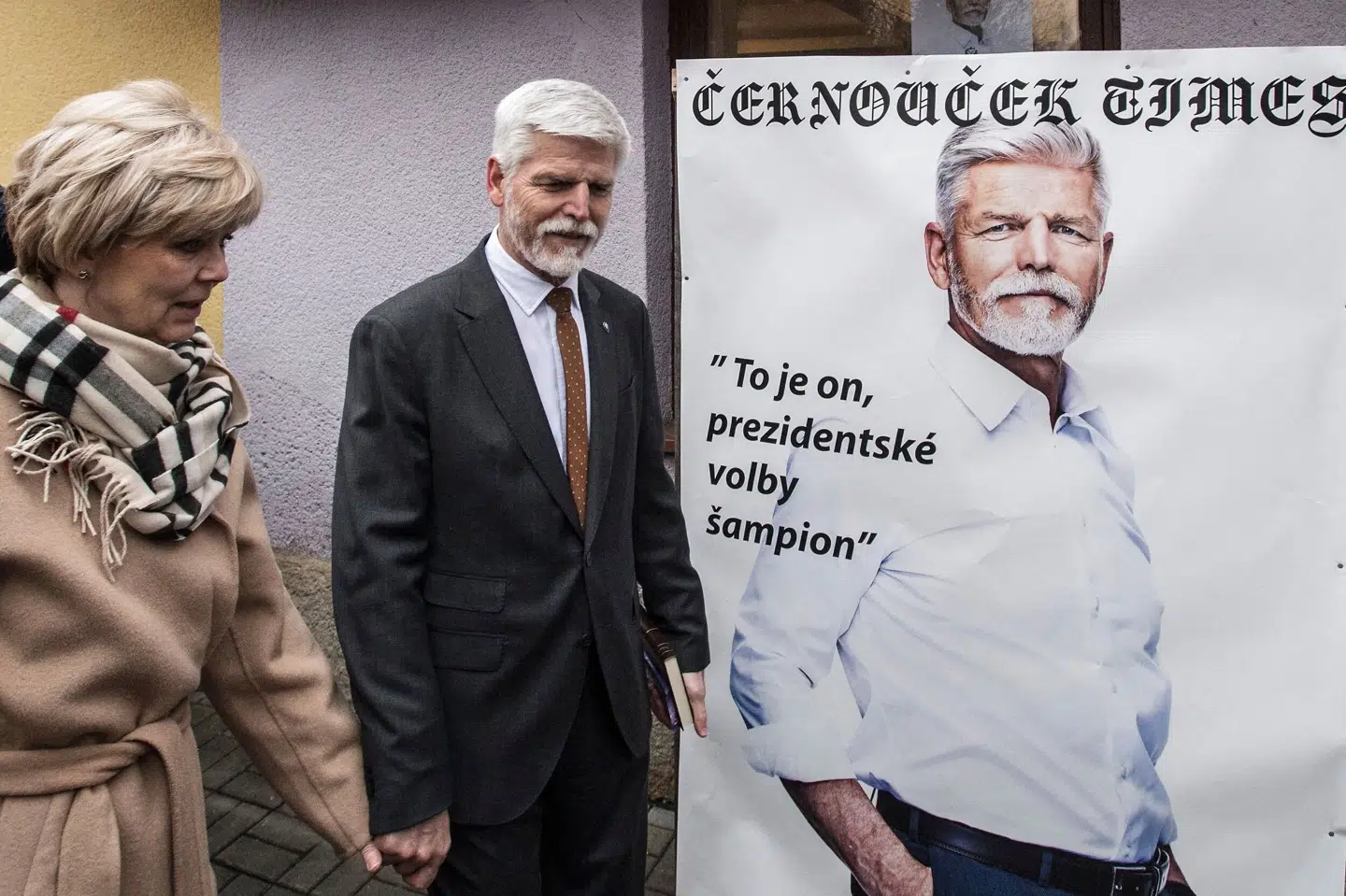 Den tidligere general Petr Pavel og hans kone Eva Pavlova foran en valgplakat af Pavel selv. De kan meget vel være det nye præsidentpar i Tjekkiet, når stemmerne ved præsidentvalget er talt op lørdag eftermiddag. Michal Cizek/Ritzau Scanpix