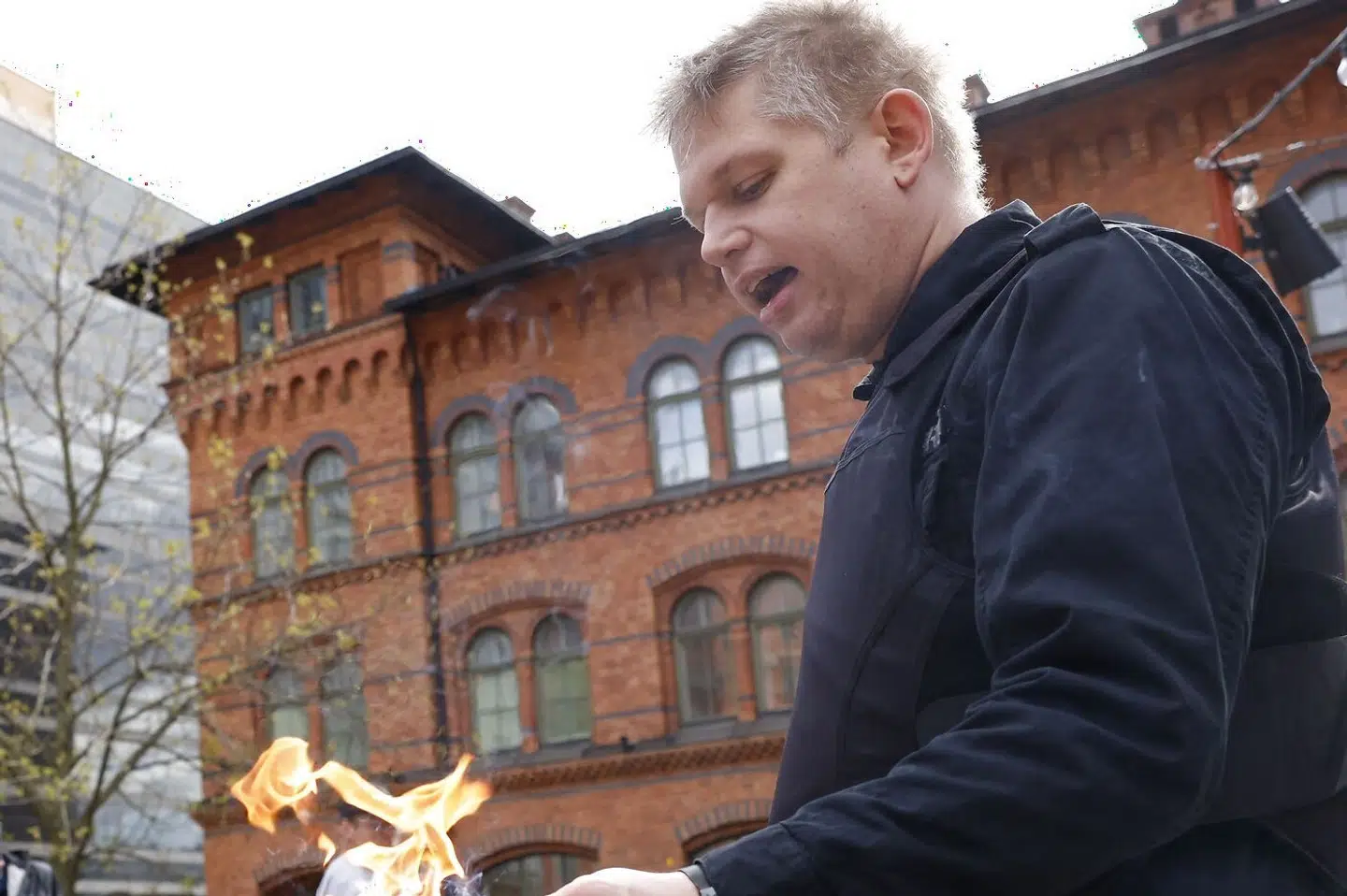 Rasmus Paludan under en koranafbrænding i maj sidste år på Norra Bantorget i Stockholm. En seance han har gentaget i mange danske byer. Men den seneste afbrænding foran den tyrkiske ambassade i den svenske hovedstad truer med af afspore Sveriges medlemskab af Nato på grund af tyrkisk modstand. Fredrik Persson/Ritzau Scanpix