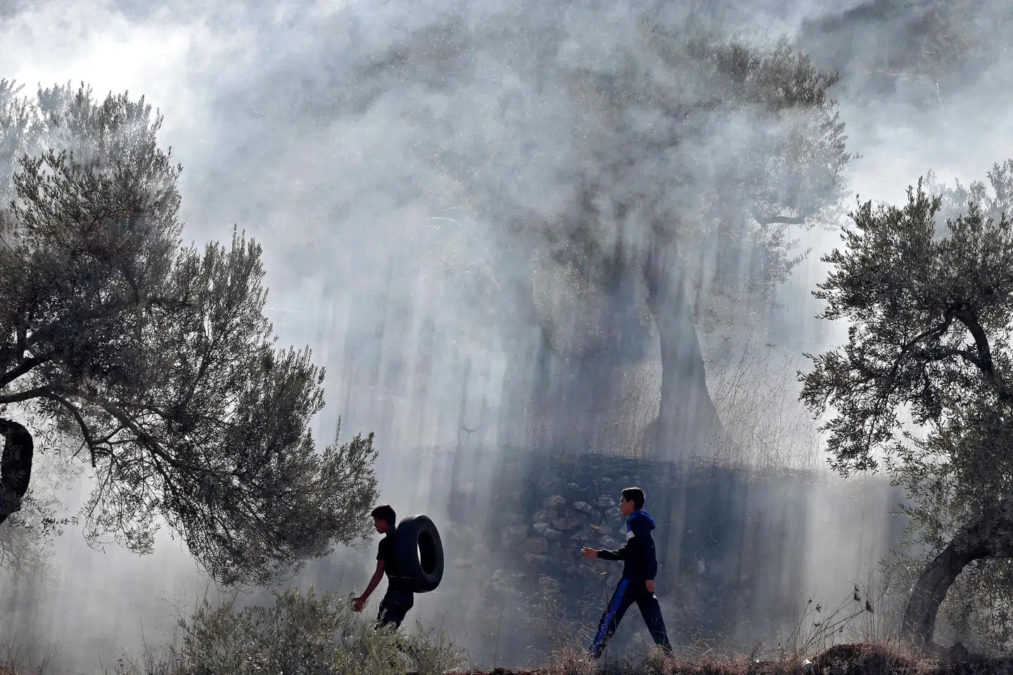 Palæstinensiske demonstranter brænder dæk af under en tidligere protest mod genoptagelsen af byggeriet ved bosætterudposten Eviatar på den besatte Vestbred. (Arkivfoto) Jaafar Ashtiyeh/Ritzau Scanpix
