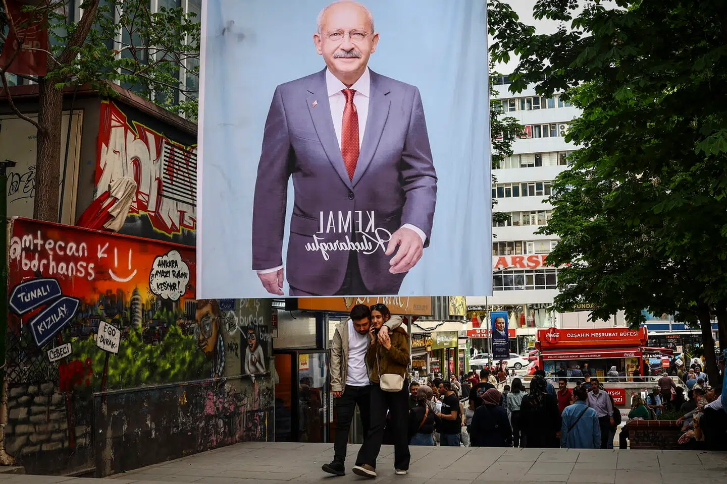 Et par går under en plakat af den tyrkiske præsidentkandidat Kemal Kilicdaroglu, leder af det oppositionelle Republikanske Folkeparti (CHP), dagen efter parlamentsvalget i Ankara, Tyrkiet, 15. maj 2023.