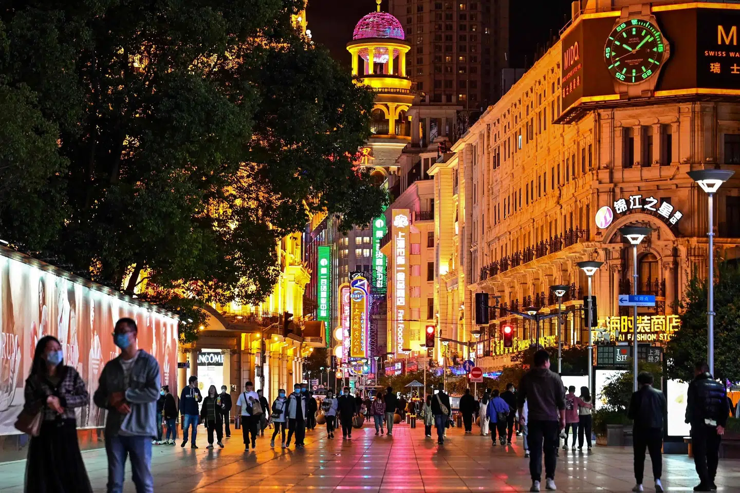 Folk går på en gågåde i millionbyen Shanghai i Kina, som melder om positive tendenser i økonomien. Flere problemer består dog ifølge analytikere. (Arkivfoto.) Hector Retamal/Ritzau Scanpix