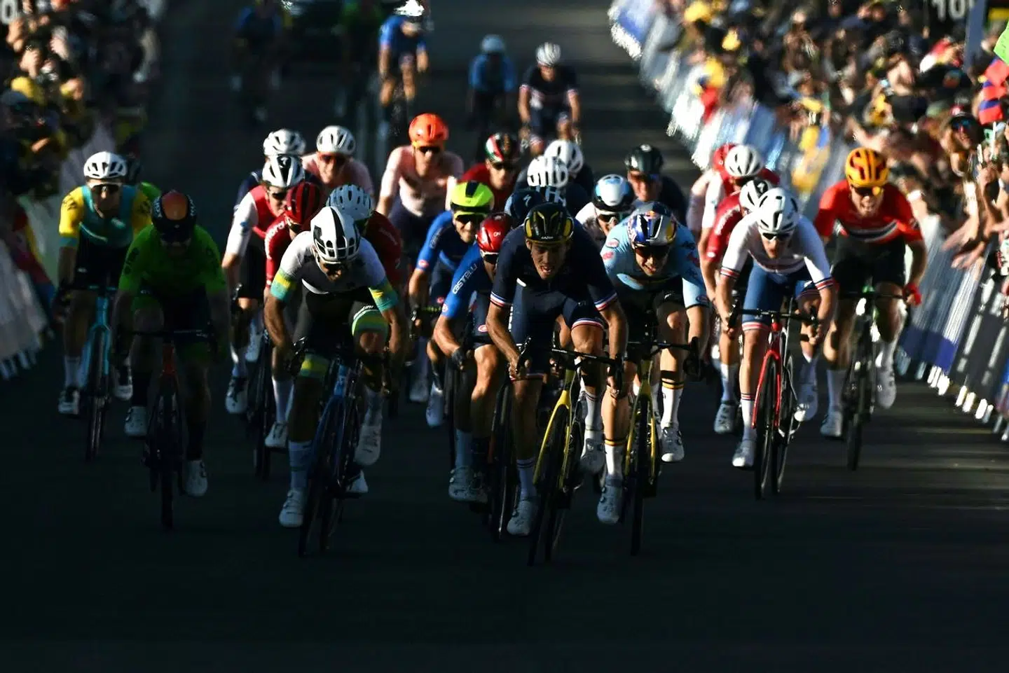 France's Christophe Laporte (C) reaches the finish line to come in second place in the men's road race cycling event at the UCI 2022 Road World Championship in Wollongong on September 25, 2022. (Photo by WILLIAM WEST / AFP) / - - IMAGE RESTRICTED TO EDITORIAL USE - STRICTLY NO COMMERCIAL USE - -