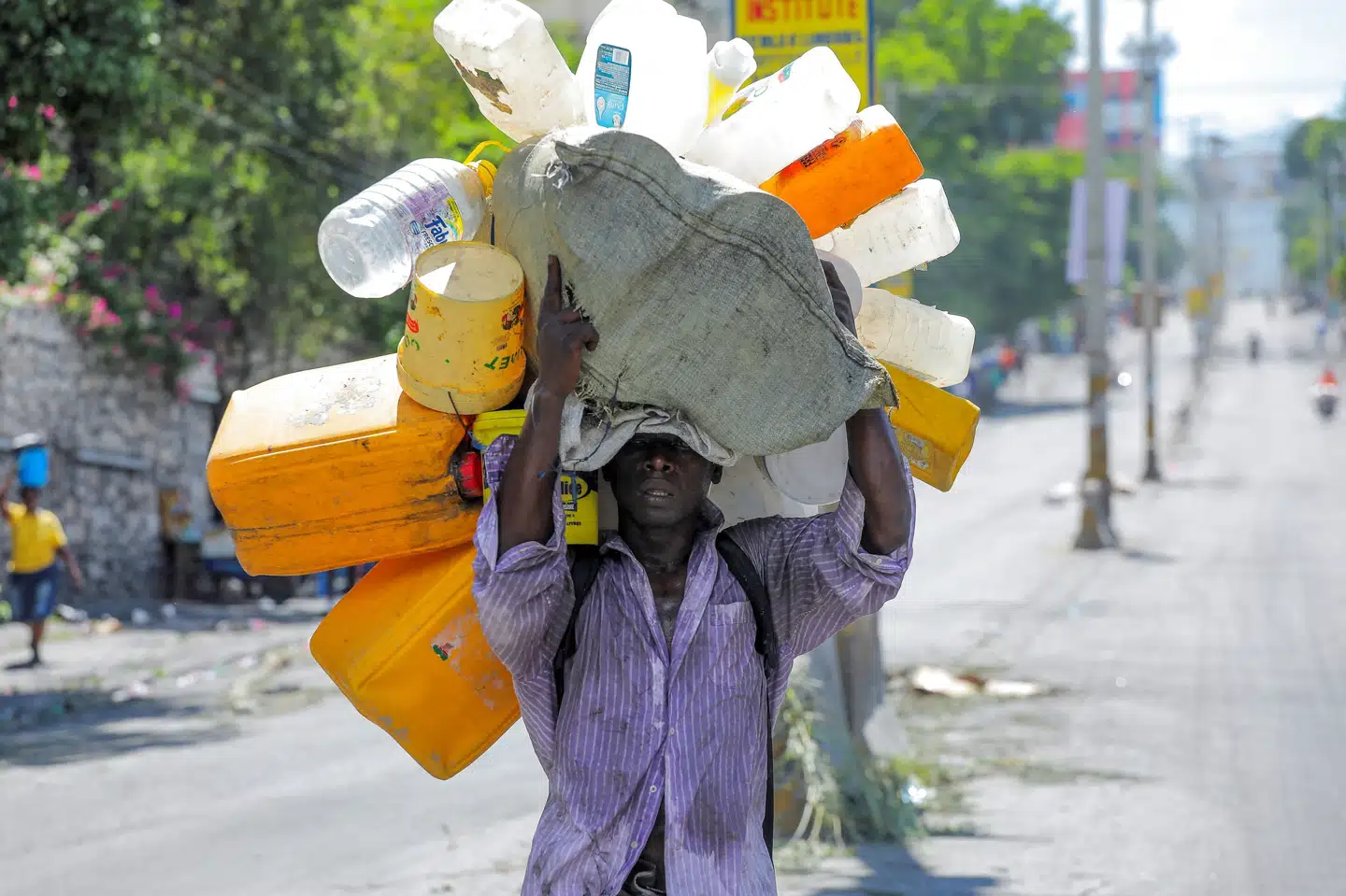 Haitianere går flere kilometer for at fylde dunke med vand i Port-au-Prince. Protester har forsinket og standset distributionen af vand. Ralph Tedy Erol/Reuters