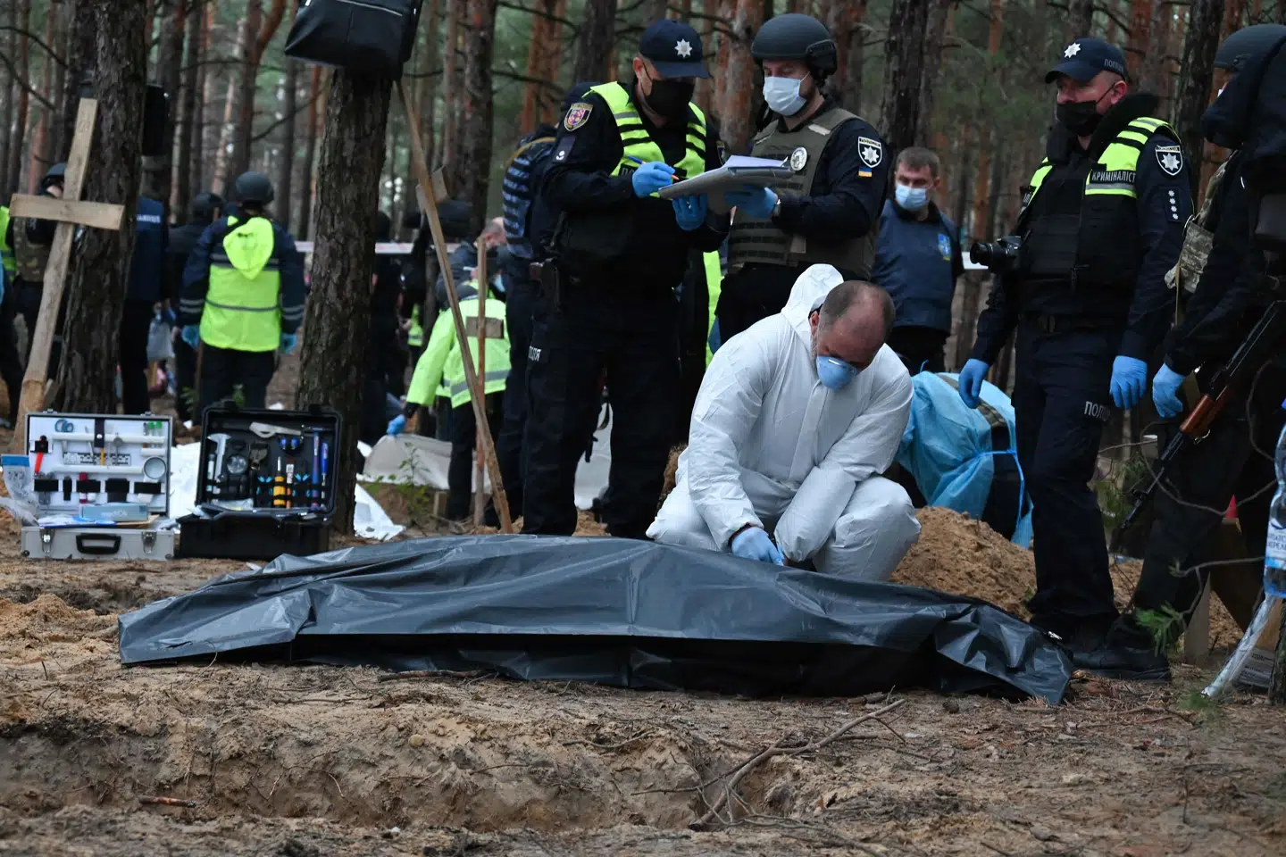 En retsmedicinsk tekniker lukker en ligpose med en af de hundredvis af døde, der er fundet i en massegrav i skovene udenfor byen Izjum i det østlige Ukraine. Sergey Bobok/Ritzau Scanpix