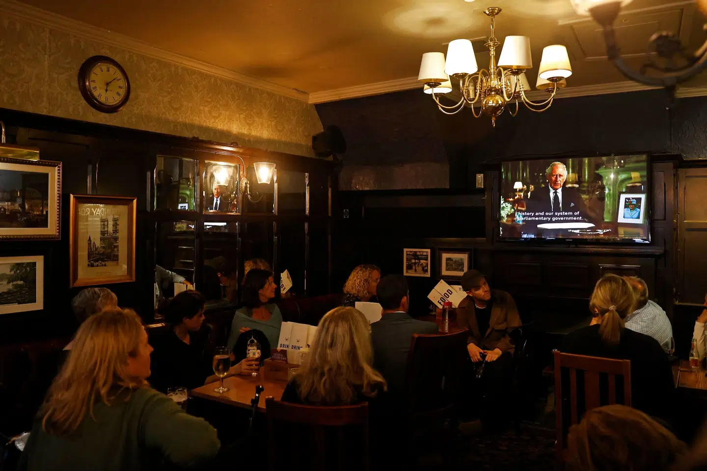 Gæster på en pub i London følger fredag aften tv-talen fra Charles, Storbritanniens nye konge, dagen efter, at dronning Elizabeth dør 96 år gammel. Carlos Jasso/Ritzau Scanpix
