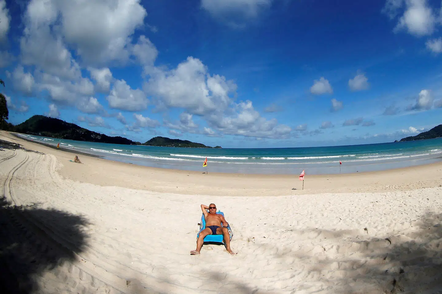 En ensom mand tager sig et solbad på stranden i Patong under pandemien.
