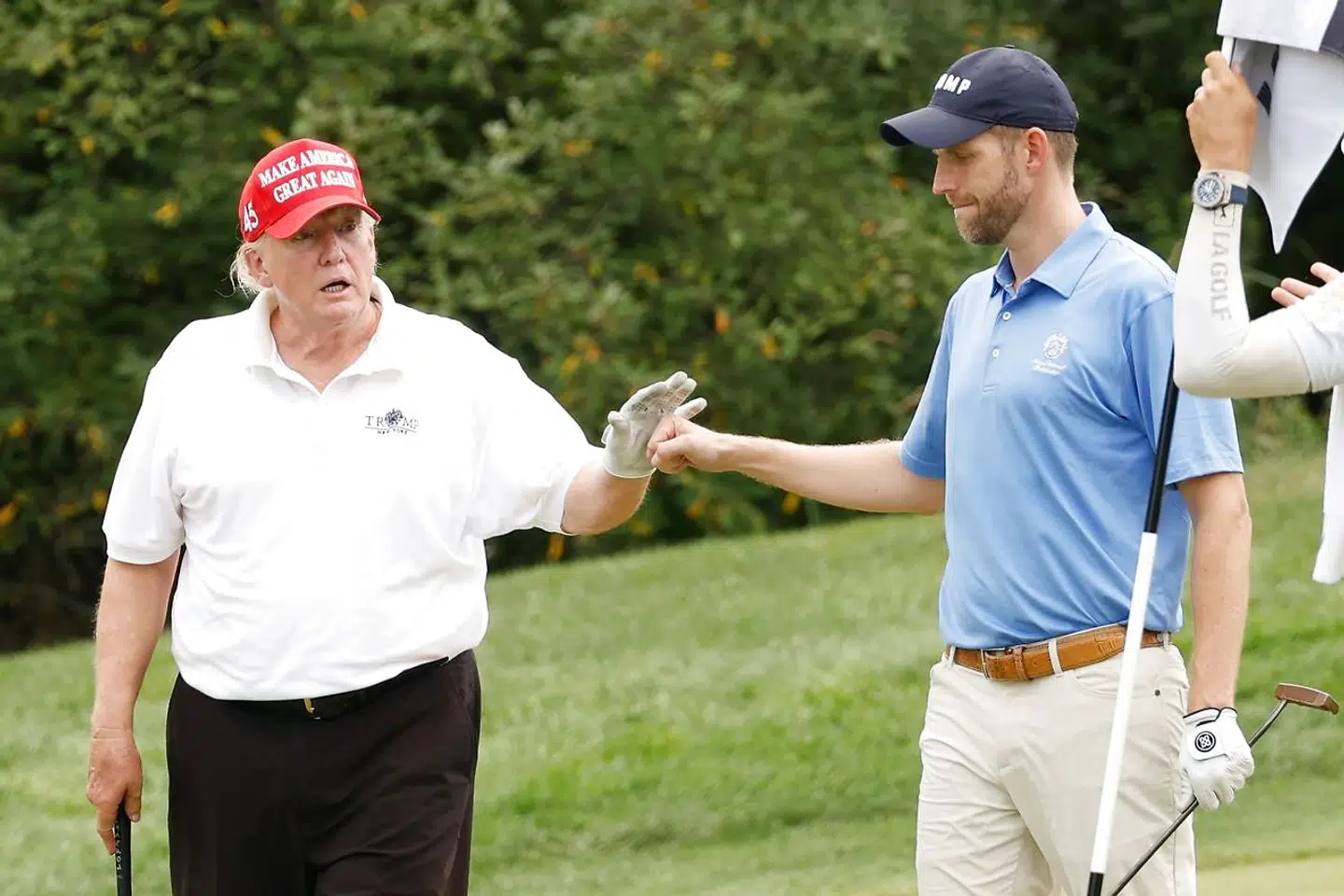 Her ses Donald Trump og sønnen Eric Trump torsdag under en runde af golfturneringen for både profesionelle og amatører forud for weekendens LIV Golf Invitational.