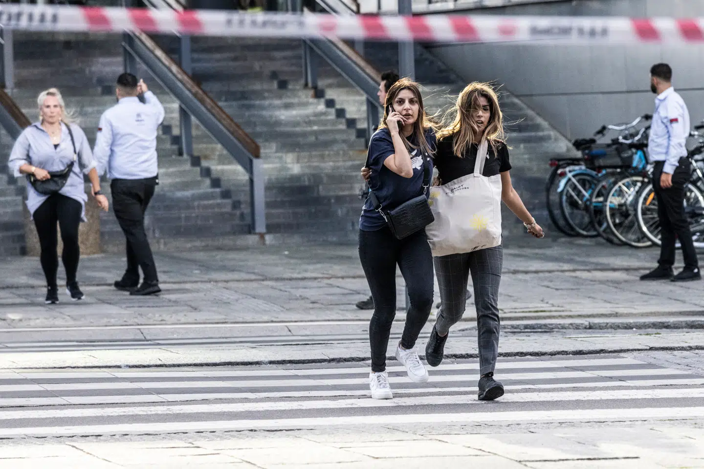 To unge kvinder løber ud af indkøbscentret Fields, hvor en 22-årig mand ifølge mistanken står bag et masseskyderi.