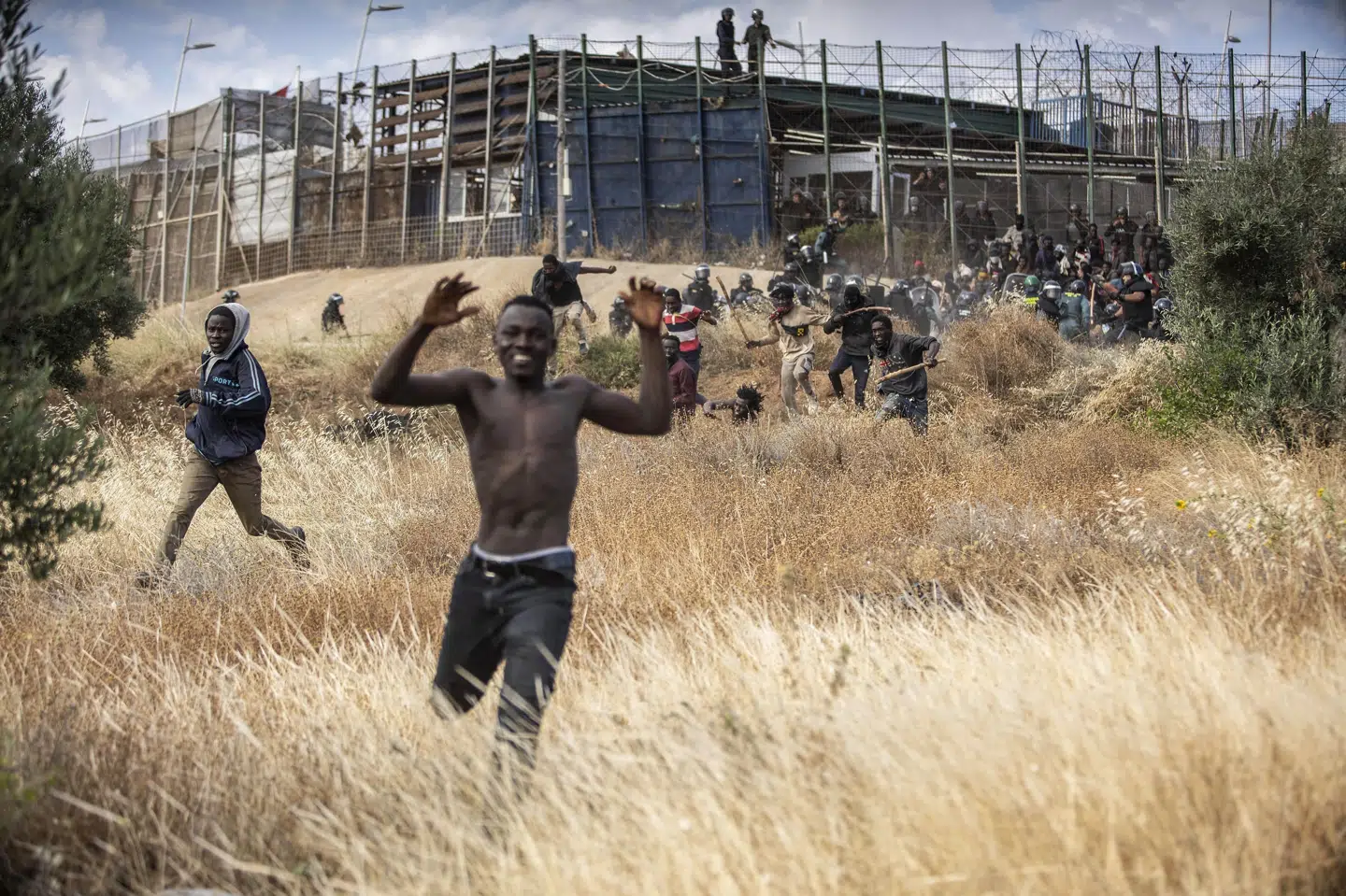 Migranter løb fredag ind på spansk territorium efter at have forceret det grænsehegn, der adskiller den spanske enklave Melilla fra Marokko. Efterfølgende har marokkanske myndigheder meddelt, at mindst 18 mennesker døde under stormløbet mod det pigtrådsomkransede grænsehegn. Javier Bernardo/Ritzau Scanpix