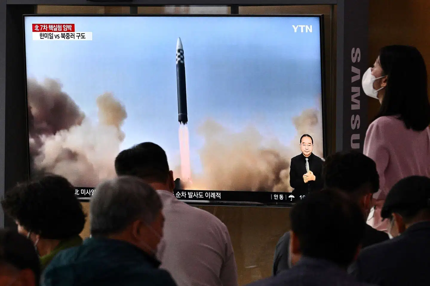 På en togstation i Seoul fulgte ventende passagerer med på tv søndag, da Nordkorea gennemførte en missiltest. Anthony Wallace/Ritzau Scanpix