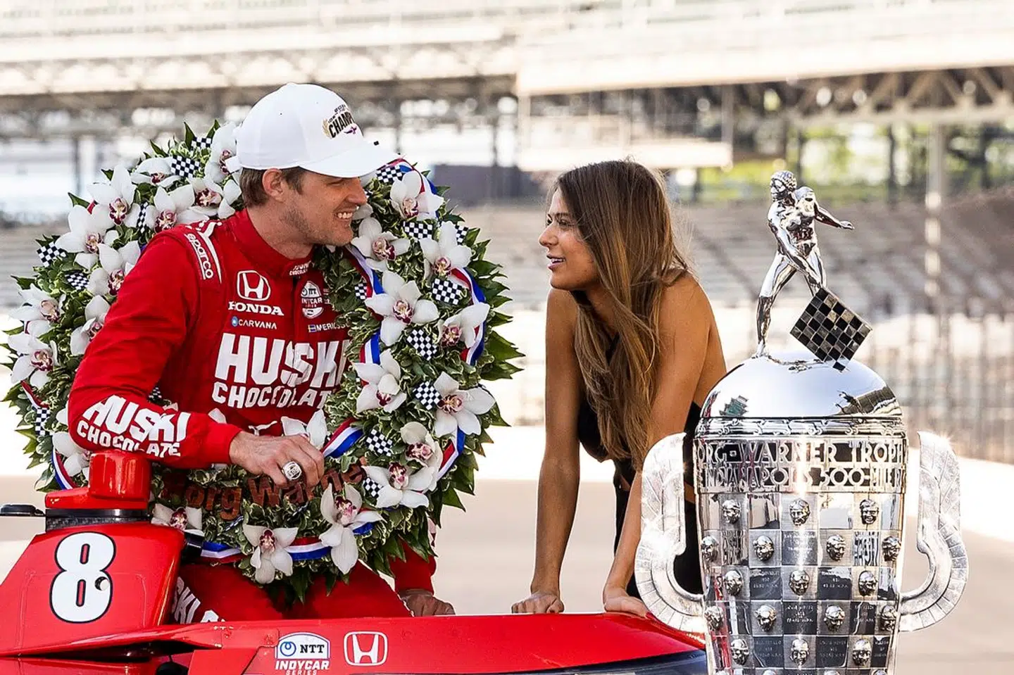 Marcus Ericsson og Iris Jondahl fejrer sejren med blomsterkrans og det store ikoniske trofæ.