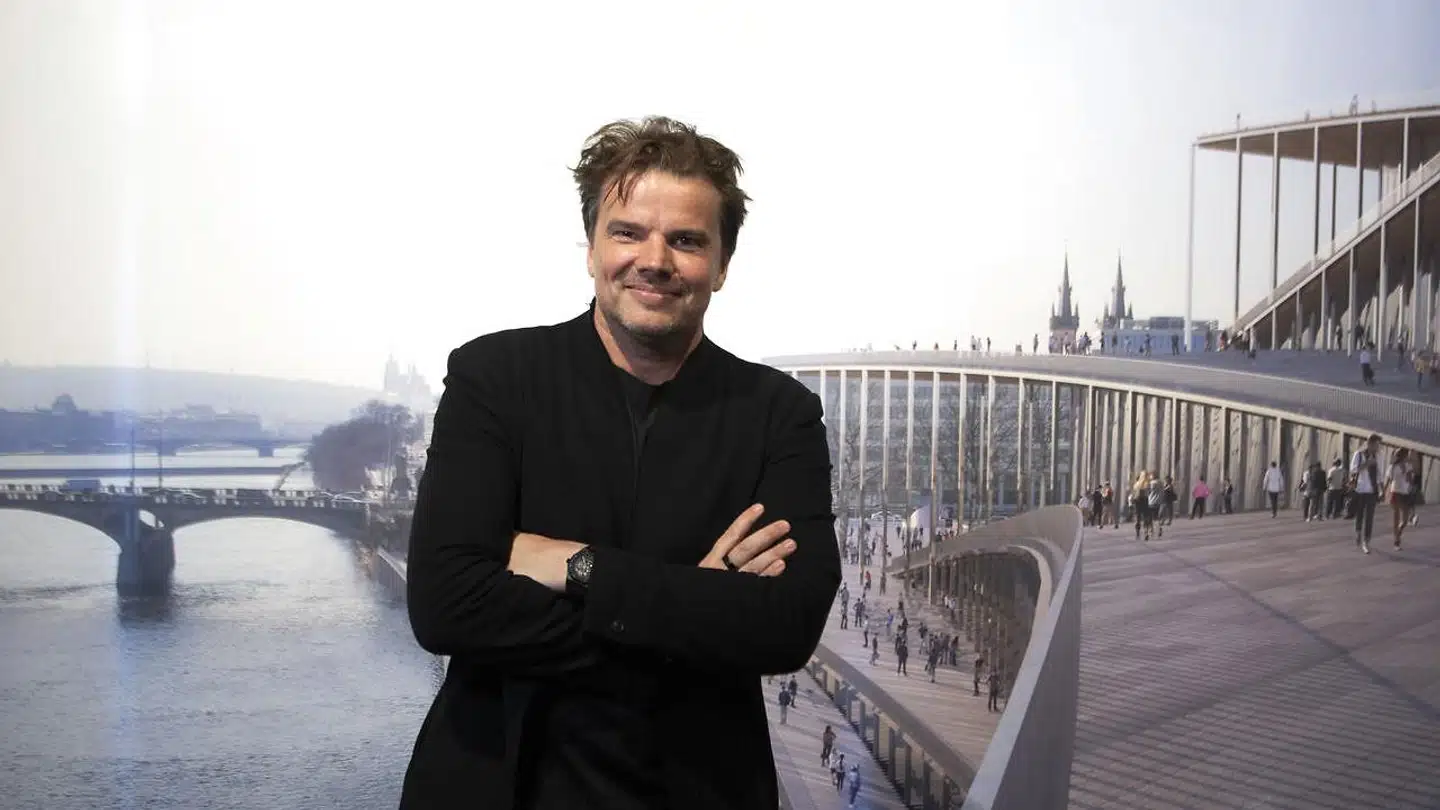 Bjarke Ingels foran en visualisering af Vltaa Philharmonic Hall.