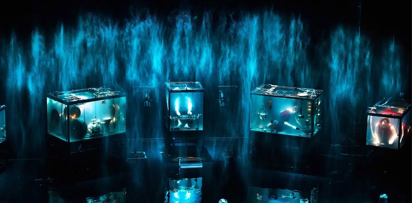 De fem musikere synger og spiller musik på specialbyggede instrumenter, mens de er under vand i store akvarier. De popper engang imellem op for at trække luft ind.