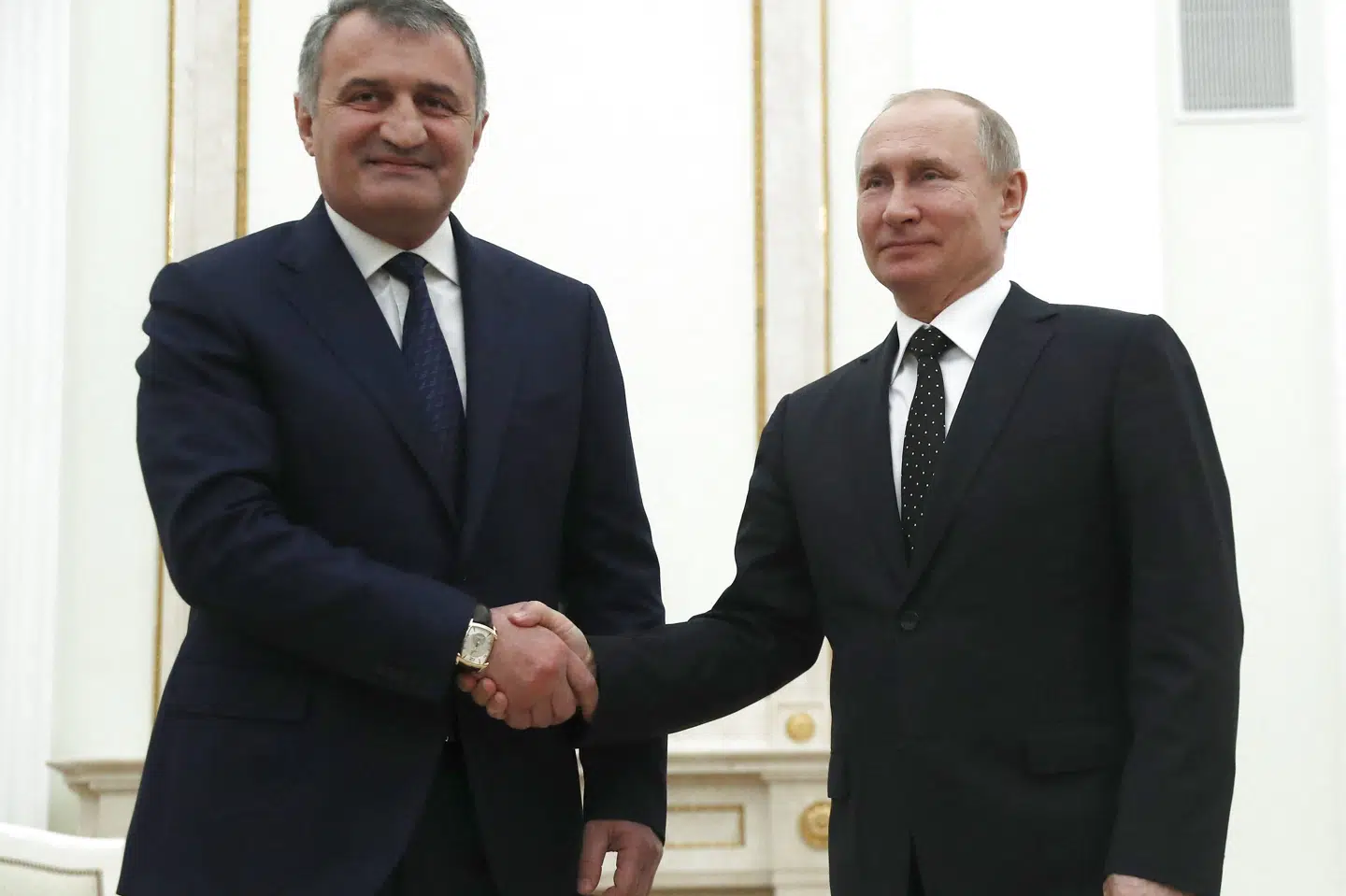 Anatolij Bibilov (tv), afgående præsident i Sydossetien, hilser her på Ruslands præsident, Vladimir Putin. Nu har Bibilov netop udskrevet folkeafstemning om at slutte Sydossetien til Rusland. (Arkivfoto) Pavel Golovkin/Ritzau Scanpix
