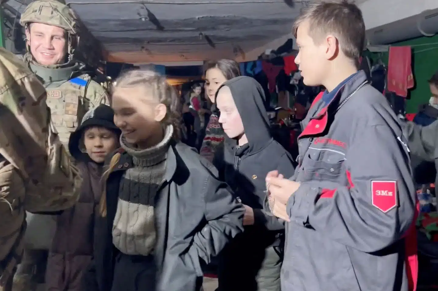 Børn ved siden af ukrainske styrker da de fredag var på vej i en bunker ved stålværket Azovstal. Det er uvist, hvor mange civile der er i området ved stålværket. Azov Battalion/Reuters