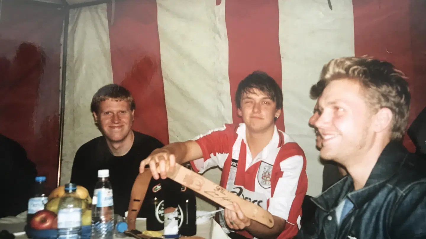 Christian Juncker og hans band efter en koncert i Den Fynske Landsby, hvor Lars Høgh besøgte dem backstage. Juncker fremviser stolt Høghs autograf.