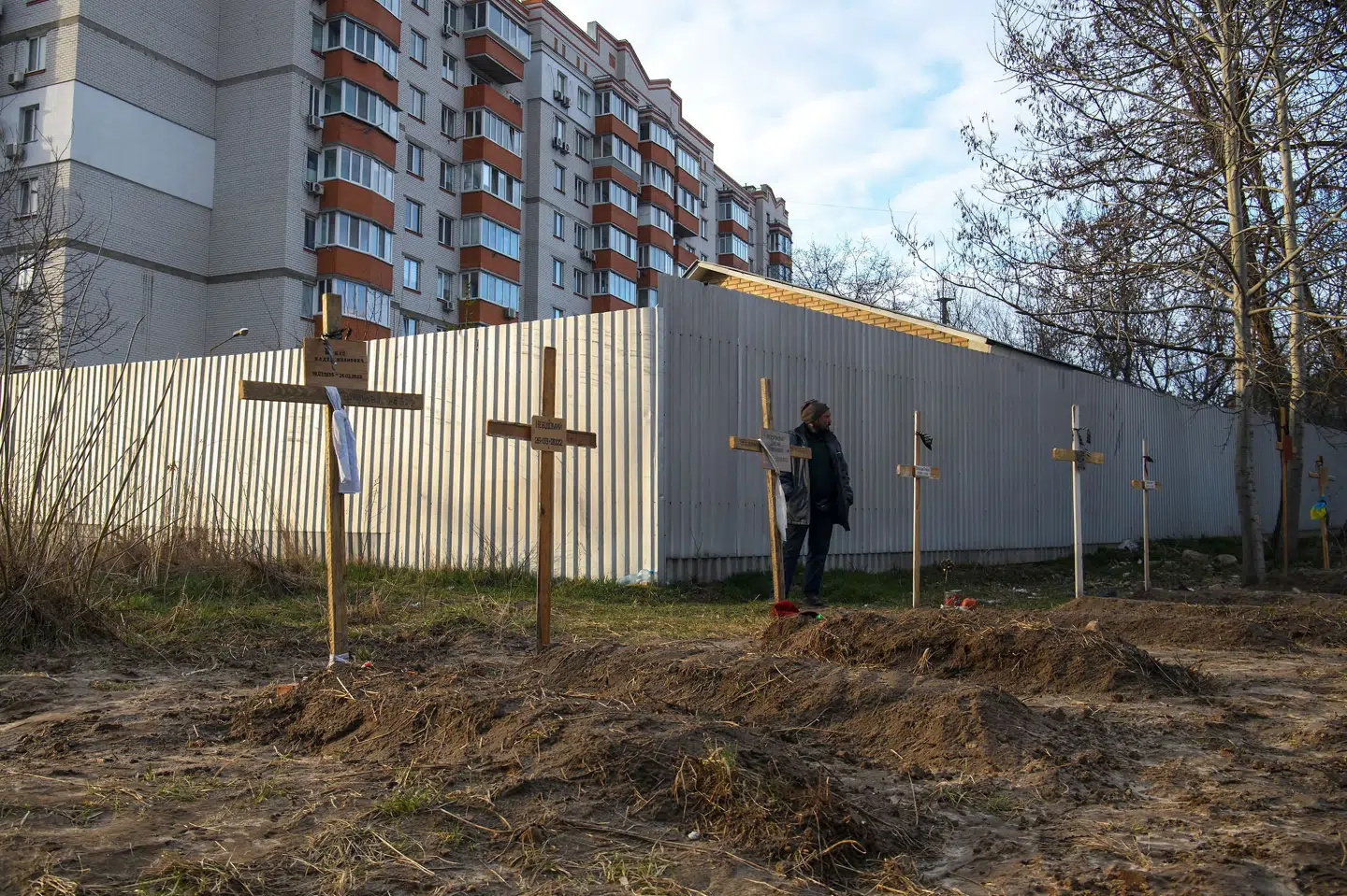 En mand ses her ved siden af en række grave med civile i byen Butja i Ukraine mandag. Ifølge lokale beboere blev de civile dræbt af russiske soldater. Stringer/Reuters