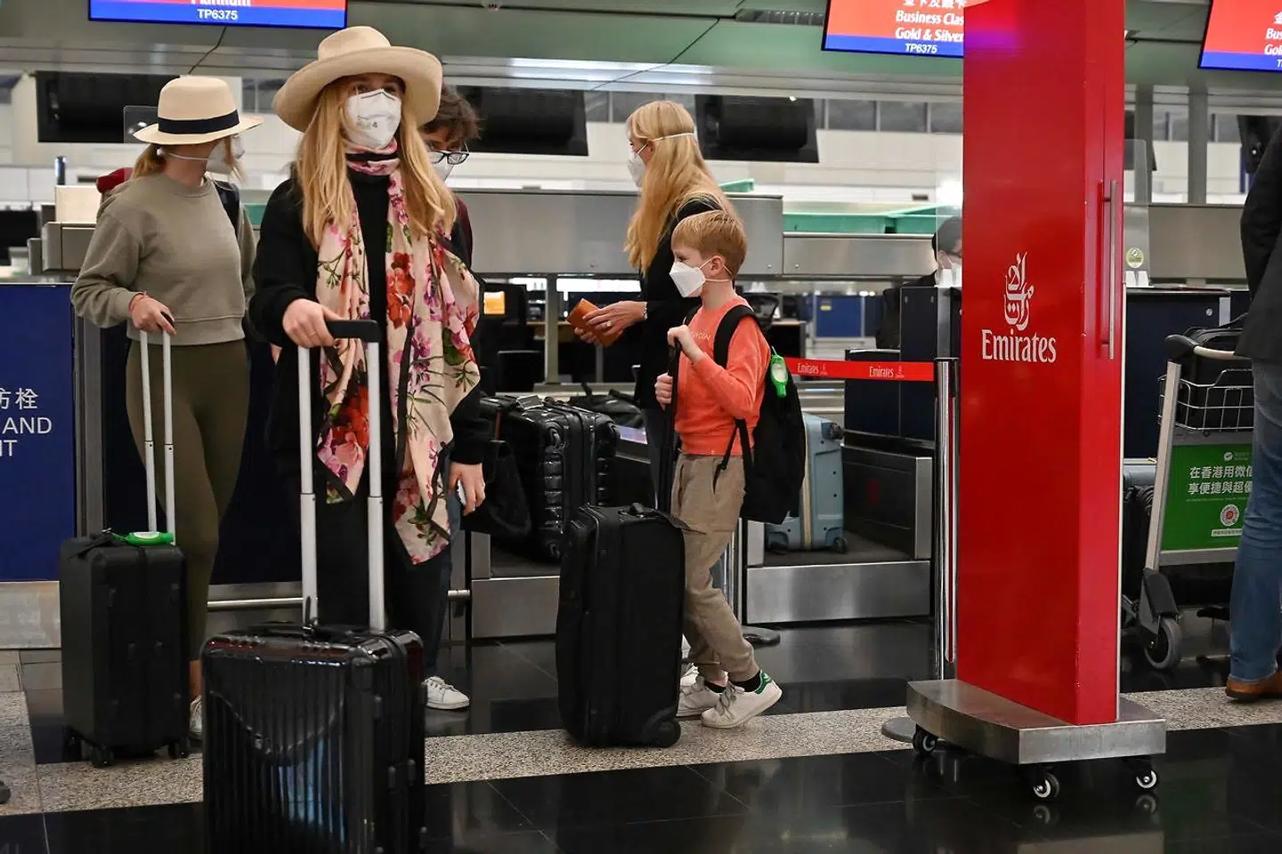 Folk står klar med kufferten foran indtjekningen i Hongkongs internationale lufthavn 8. marts 2022.