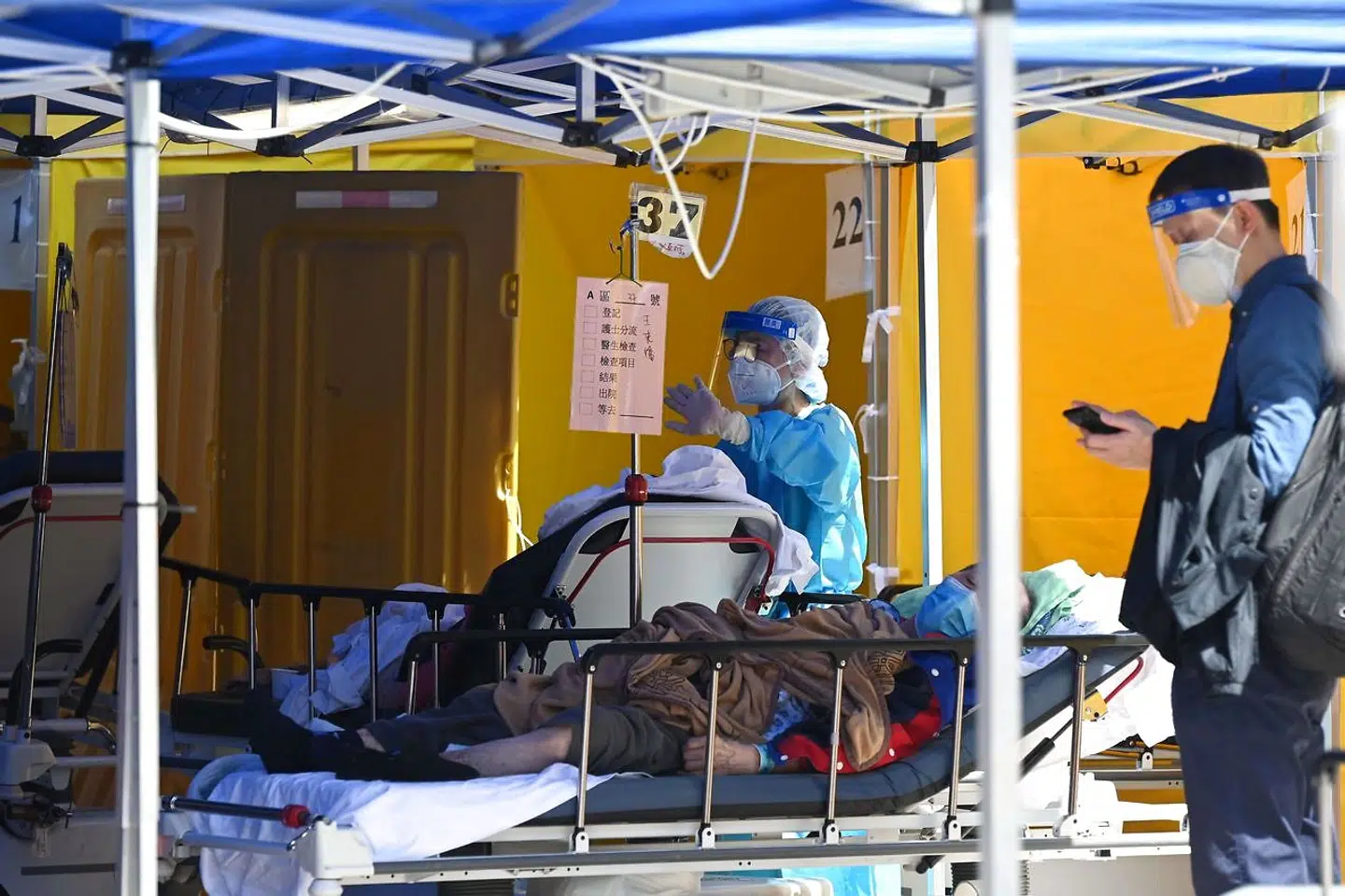 Syge folk ligger på senge uden for Caritas-hospitalet i Hongkong den 1. marts 2022.