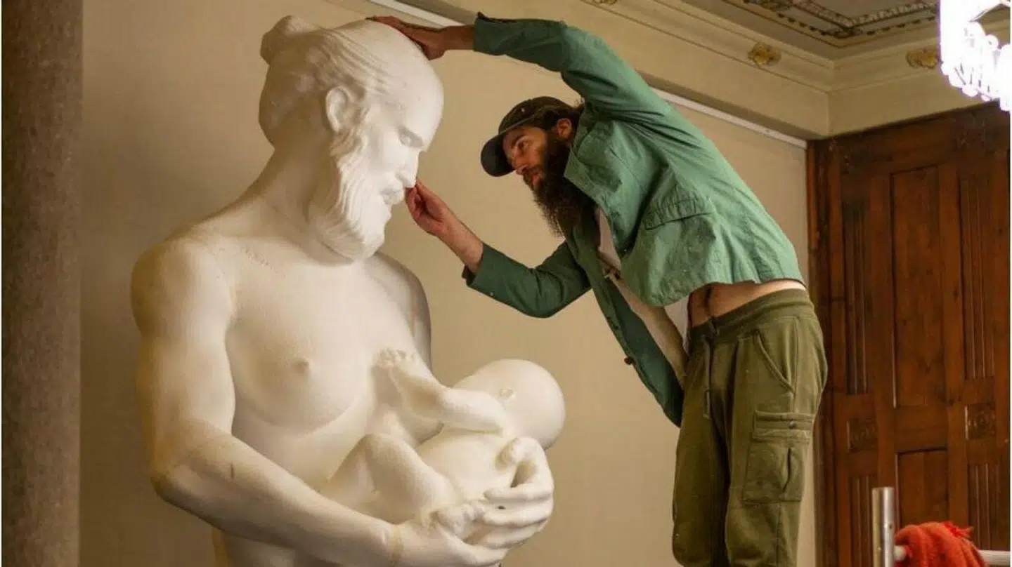 Den 3,5 meter høje statue forestiller en klassisk mandeskikkelse, der ammer et barn. Men skulpturen har skabt forargelse og kritik.