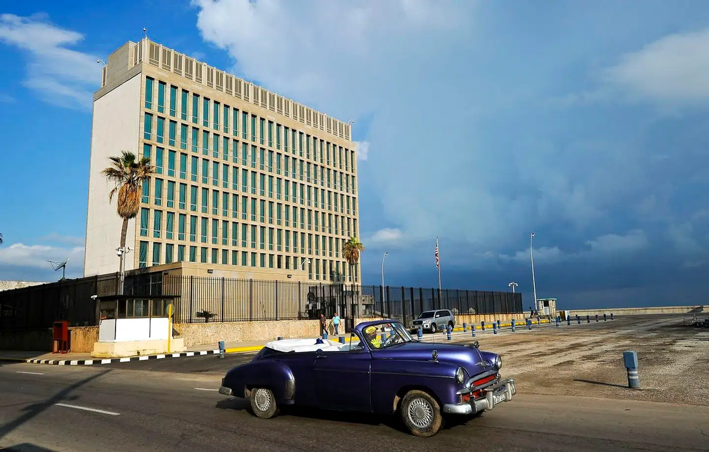 En gammel bil passerer den amerikanske ambassade i Havana i Cuba.