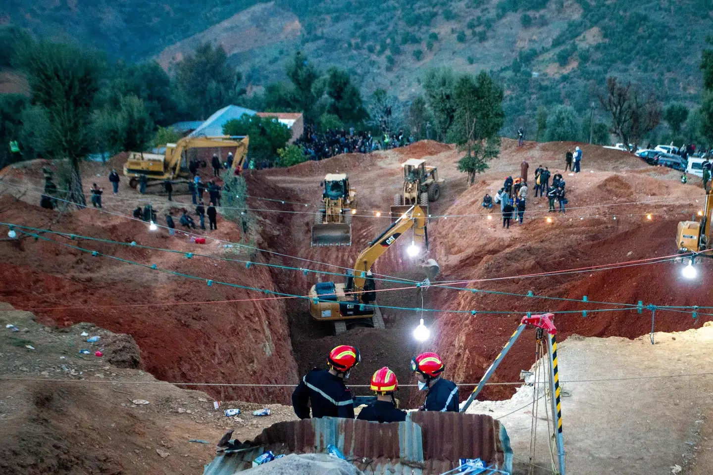 Mindst fem gravemaskiner har siden tirsdag lavet en enorm udgravning ved siden af den brønd, som den femårige dreng sidder fast i. (Foto af AFP) -/Ritzau Scanpix
