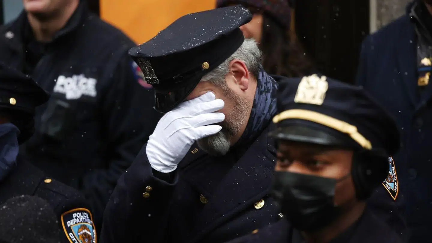 En NYPD-betjent reagerer ved fredagens afsked med den 22-årige kollega Jason Rivera, der blev dræbt i sidste uge.